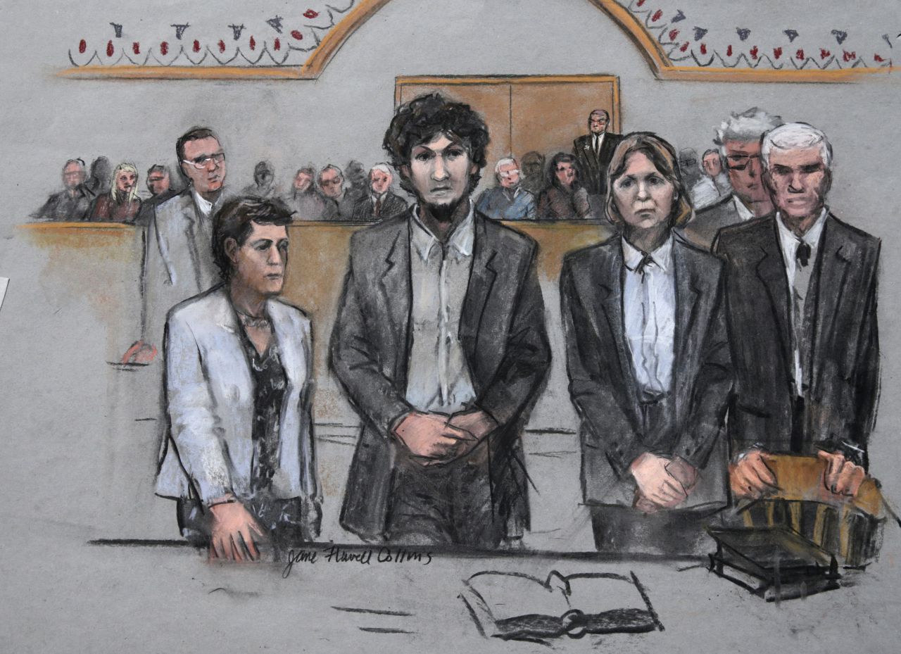 In this courtroom sketch, Boston Marathon bomber Dzhokhar Tsarnaev, center, stands with his defense attorneys as a death by lethal injection sentence is read at the Moakley Federal court house in the penalty phase of his trial in Boston, Friday, May 15, 2015. The federal jury ruled that the 21-year-old Tsarnaev should be sentenced to death for his role in the deadly 2013 attack. (Jane Flavell Collins via AP)