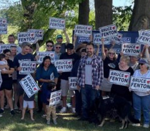 Bruce Fenton in the plaid shirt, his work dog to his right, and Mary Maxwell to the dog's right